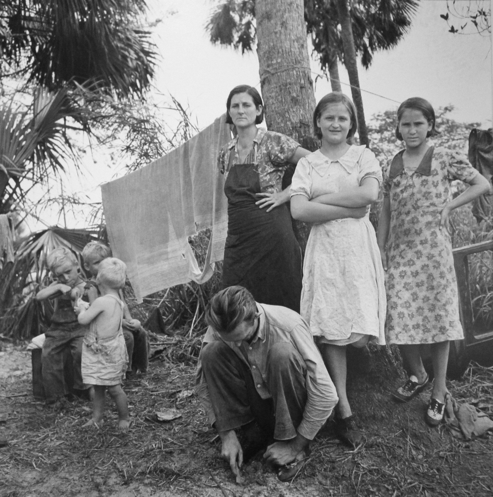Marion Post Wolcott, Migrant family from Missouri camping out in cane brush. One woman said, “We ain’t never lived like hogs before but we sure does now.” Canal Point, Florida, 1939, gelatin silver print, signed, 16 x 20 inches